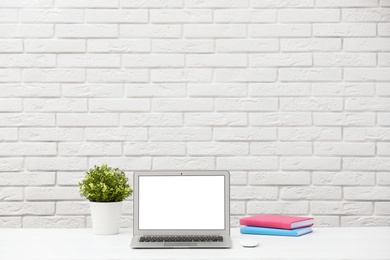 Laptop with blank screen on table indoors. Space for text