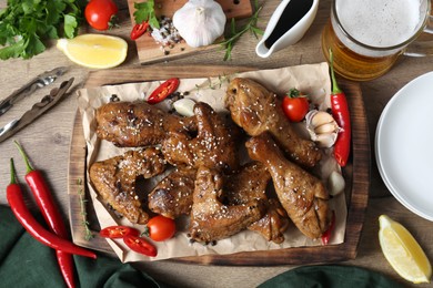 Photo of Tasty chicken glazed in soy sauce and different products on wooden table, flat lay