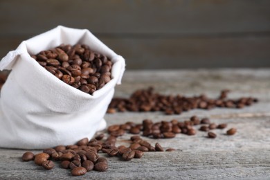 Photo of Bag of roasted coffee beans on wooden table, closeup. Space for text