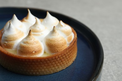 Tartlet with meringue on grey table, closeup and space for text. Delicious dessert