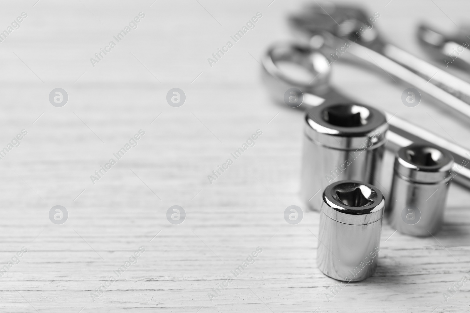 Photo of Auto mechanic's tools on white wooden background, closeup. Space for text