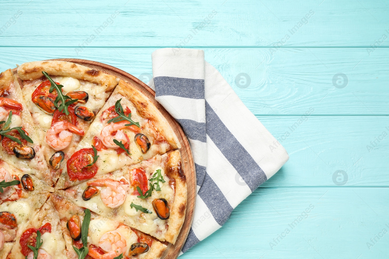 Photo of Delicious seafood pizza on light blue wooden table