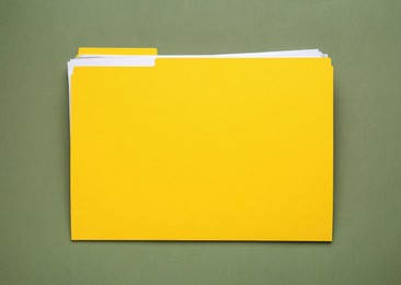 Yellow file with documents on olive background, top view