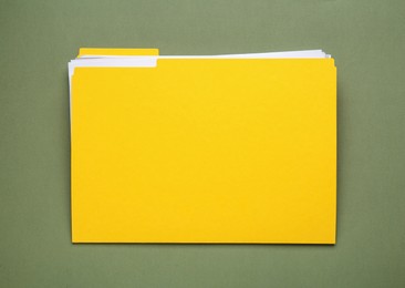 Photo of Yellow file with documents on olive background, top view