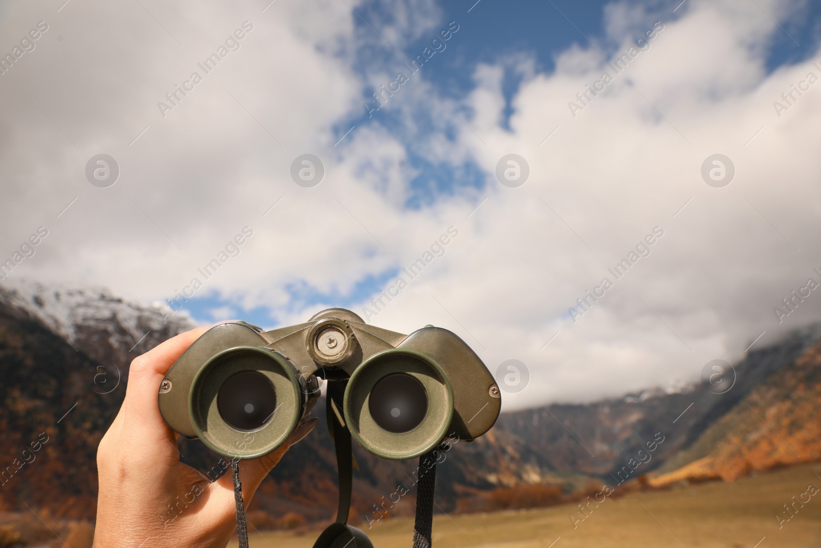 Photo of Boy holding binoculars in beautiful mountains, closeup. Space for text