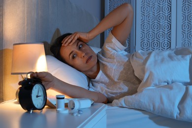 Photo of Mature woman suffering from insomnia in bed at night