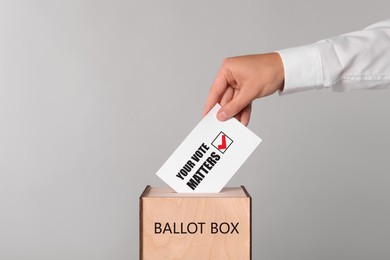 Image of Man putting paper with text Your Vote Matters and tick into ballot box on light grey background
