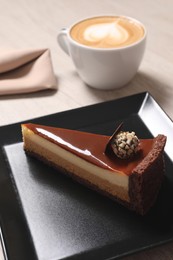 Photo of Piece of delicious cheesecake with caramel and coffee on table, closeup