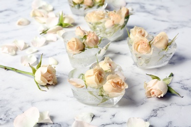 Heart shaped ice cubes with roses on marble background