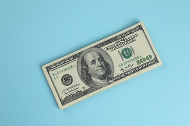 Photo of Money exchange. Dollar banknotes on light blue background, top view