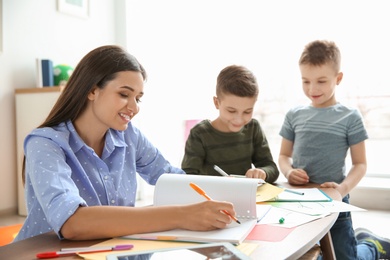 Cute little children with teacher in classroom at school