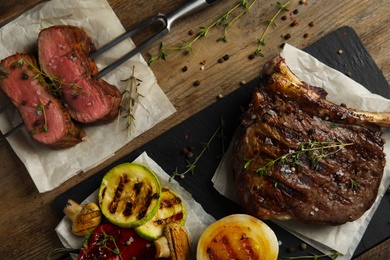 Flat lay composition with grilled meat on wooden table