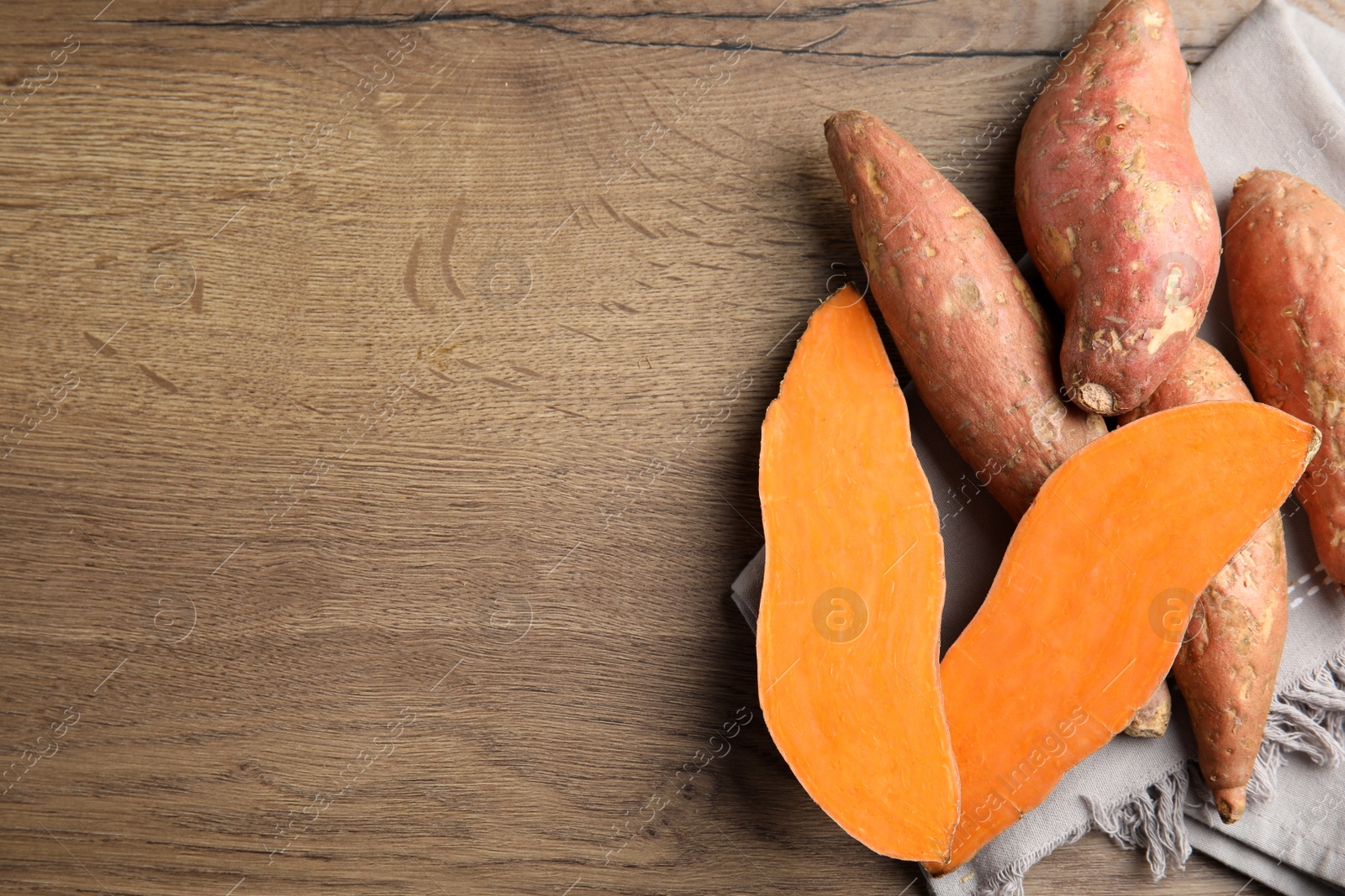 Photo of Flat lay composition with sweet potatoes and space for text on wooden background