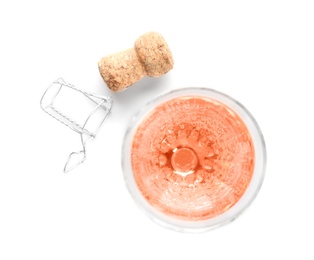 Glass of rose champagne and cork plug on white background, top view