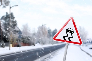 Image of Highway with Slippery Surface road sign on snowy day, space for text