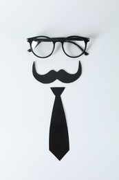 Photo of Fake mustache, tie and glasses on light background, top view