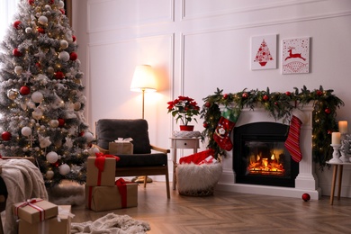 Stylish room interior with fireplace and beautiful Christmas tree