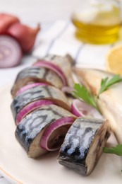 Photo of Tasty salted mackerel, parsley and onion on plate, closeup