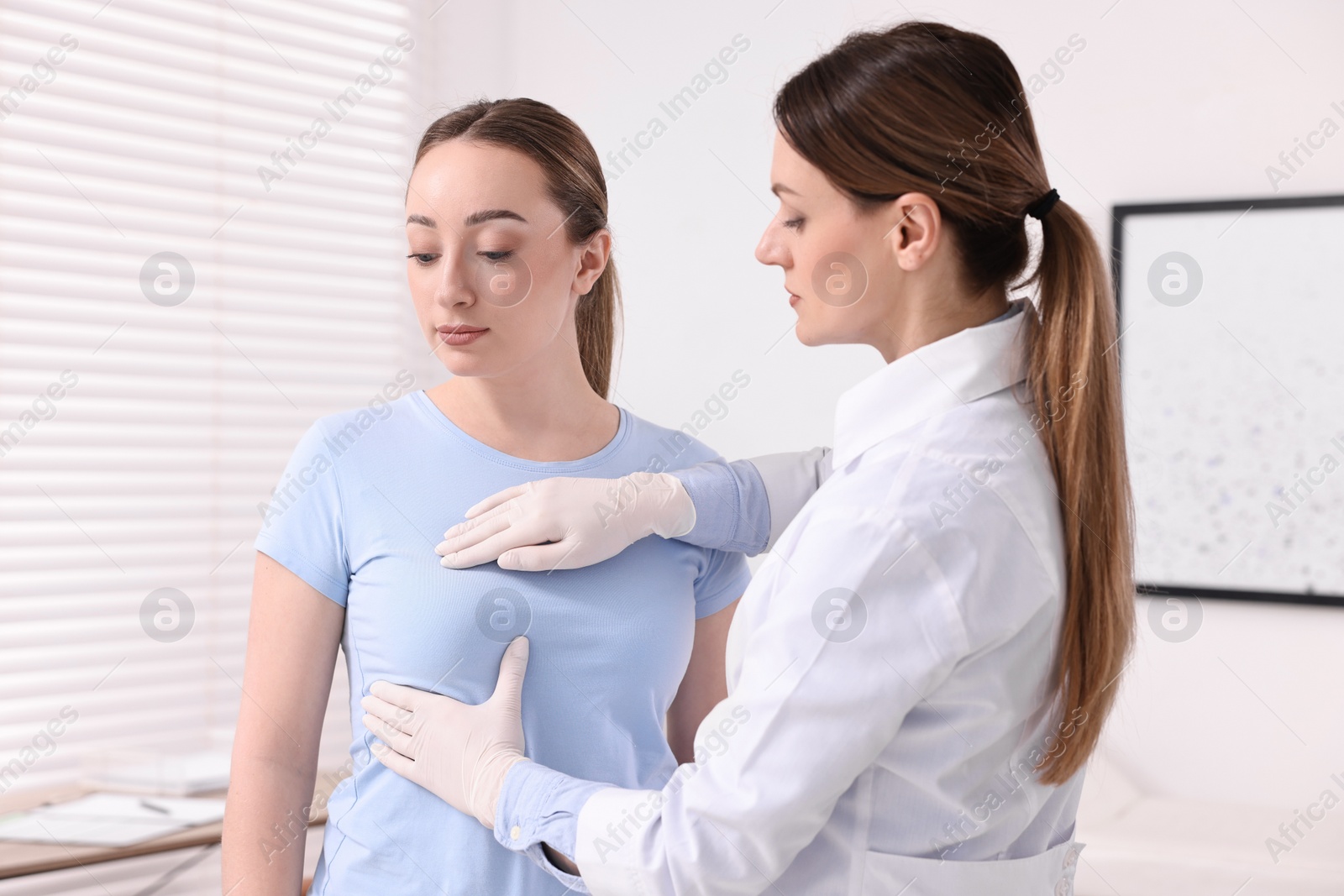 Photo of Mammologist checking young woman's breast in hospital