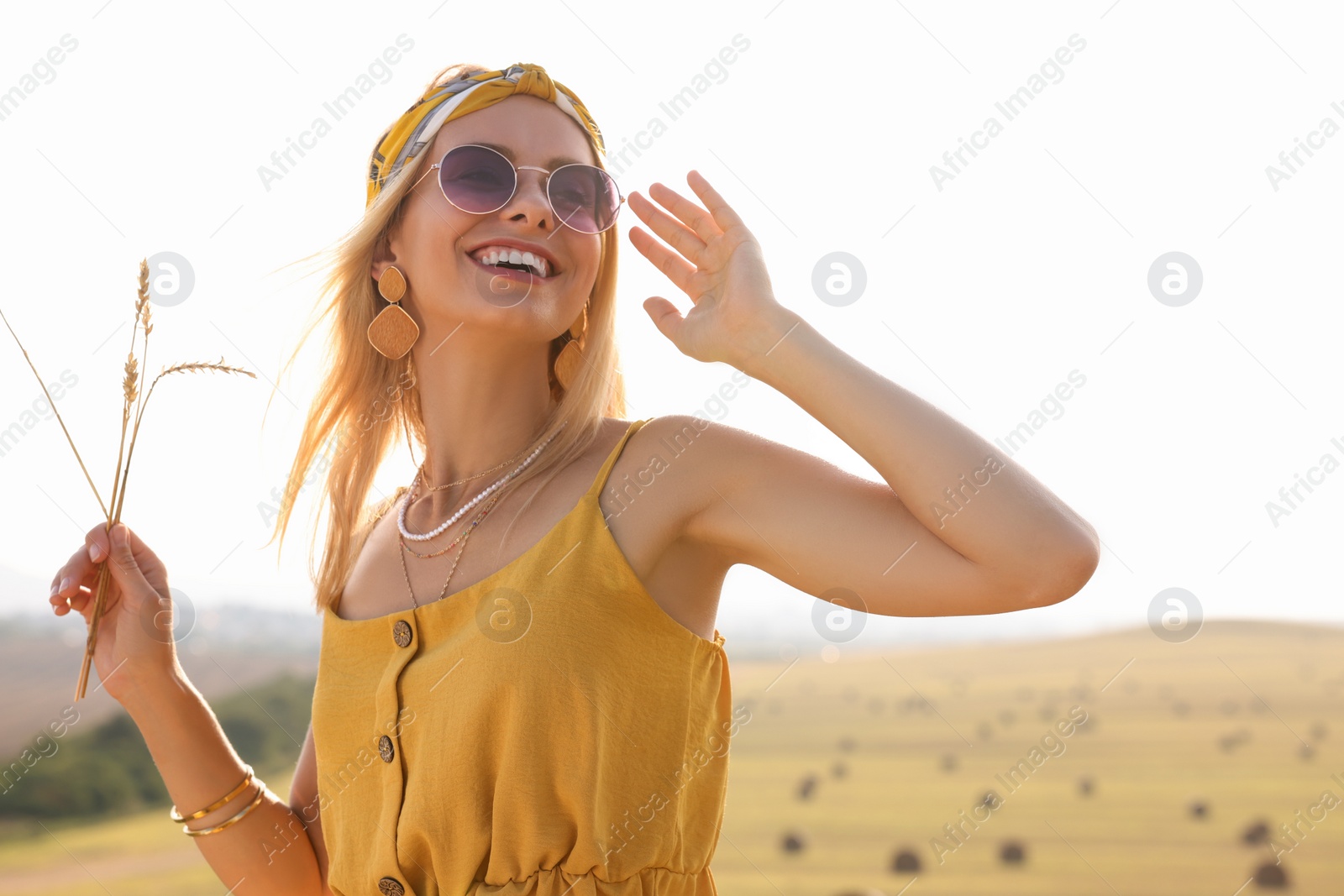 Photo of Beautiful happy hippie woman with spikelets in field