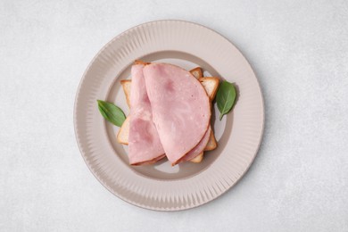 Photo of Delicious sandwich with ham on light table, top view