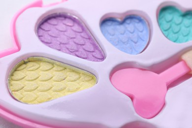 Photo of Decorative cosmetics for kids. Eye shadow palette with applicator as background, closeup