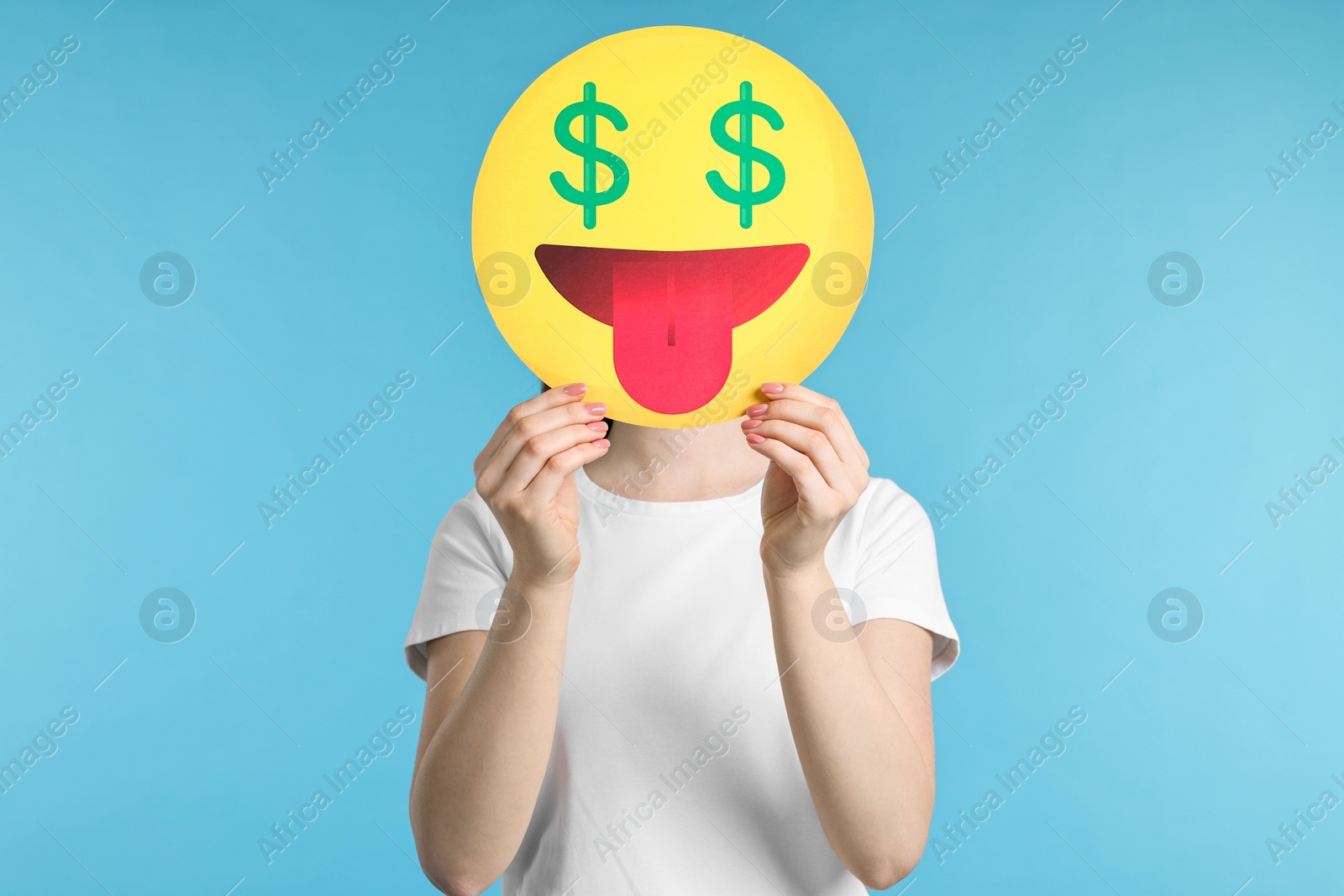 Photo of Woman covering face with dollar signs instead of eyes on light blue background