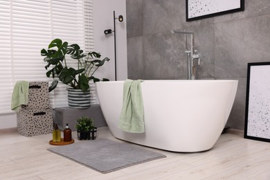 Stylish bathroom interior with soft bath mat and tub