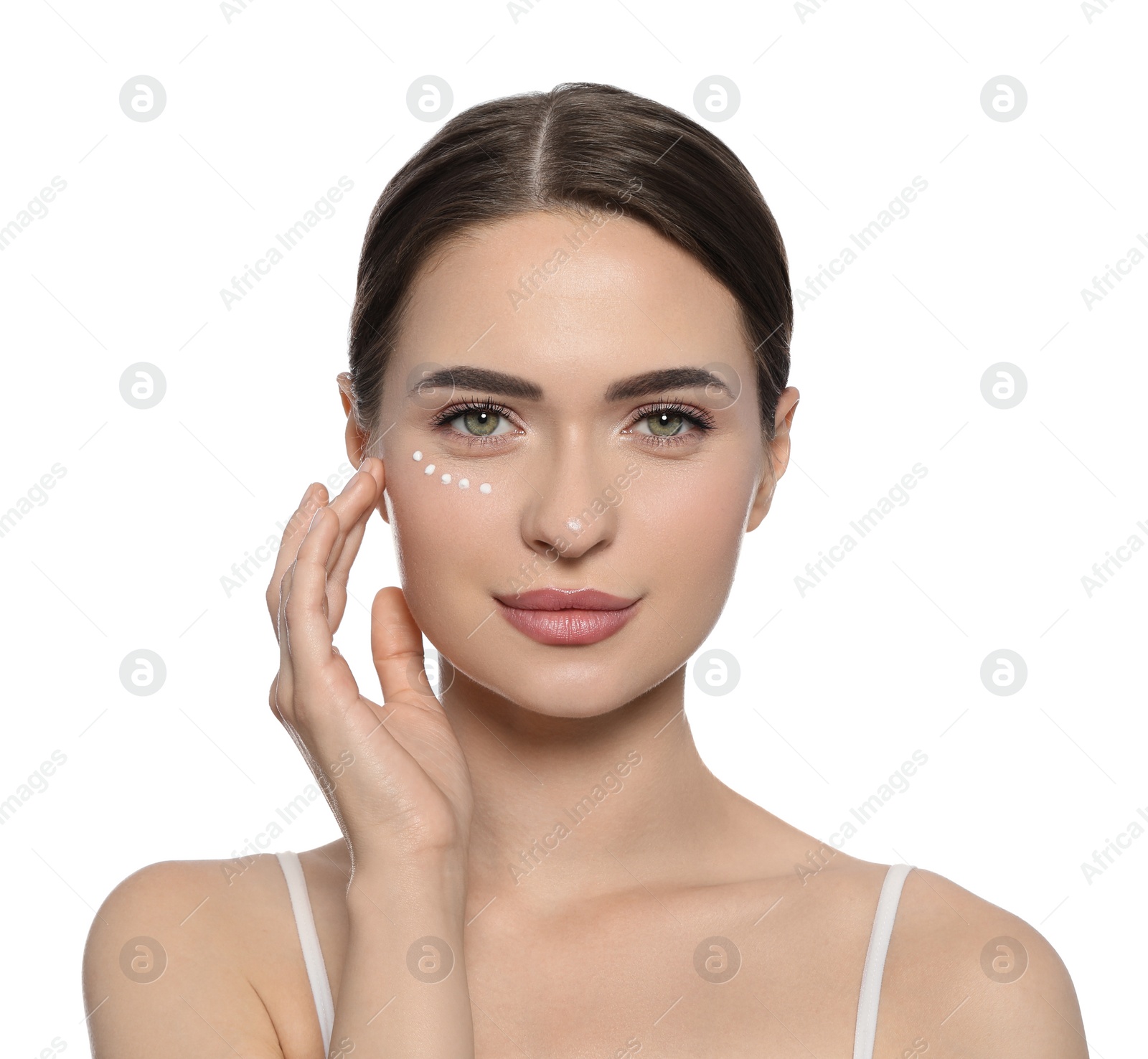 Photo of Young woman with cream around eye on white background