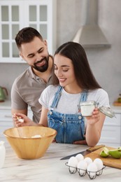 Happy young couple cooking together in kitchen