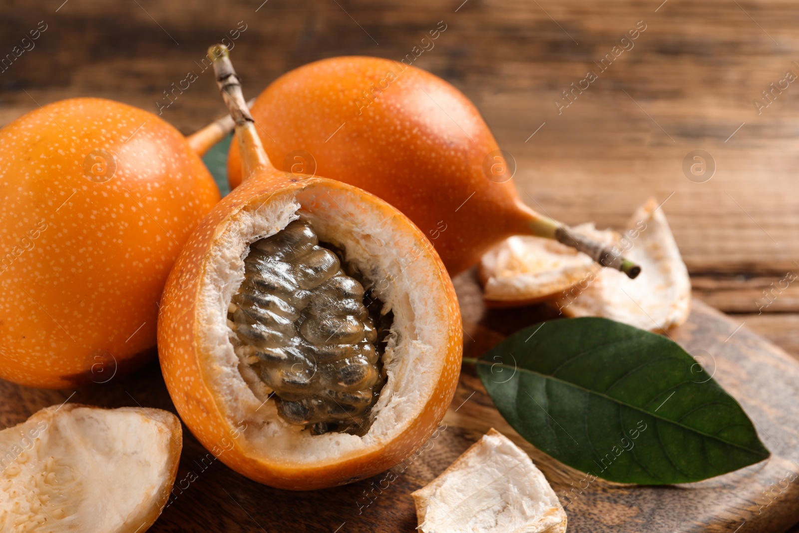 Photo of Delicious ripe granadillas on wooden table, closeup