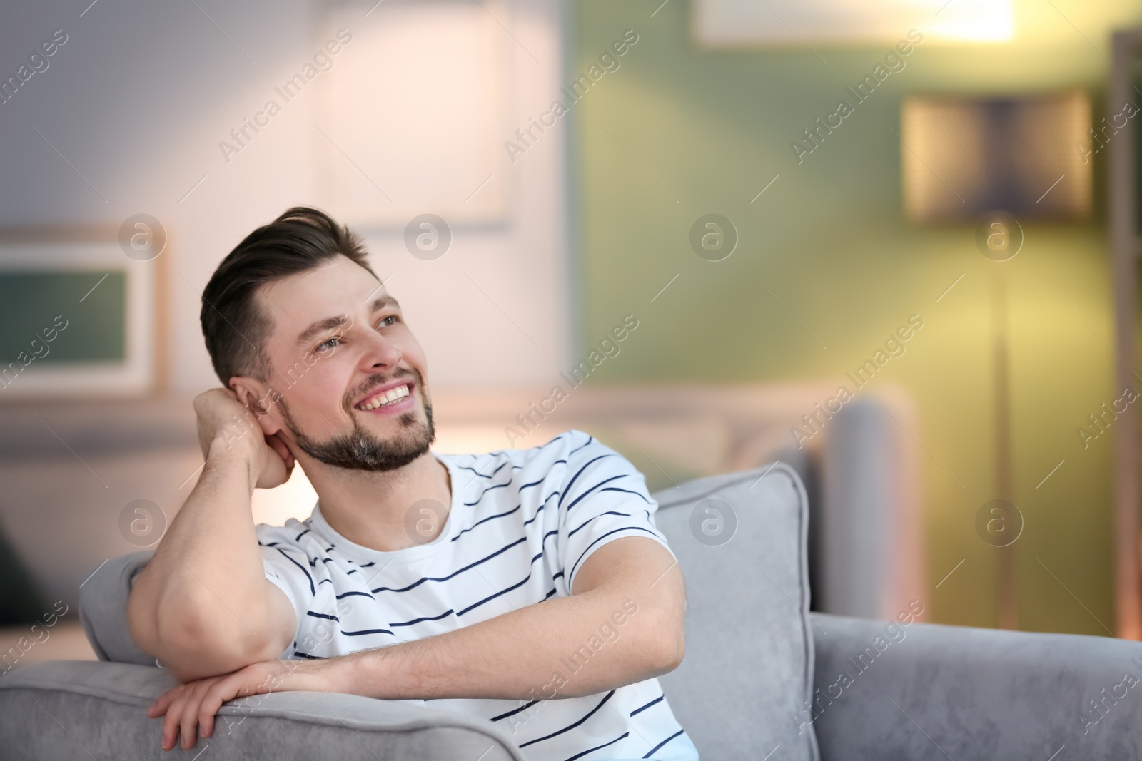 Photo of Young man sitting in armchair at home