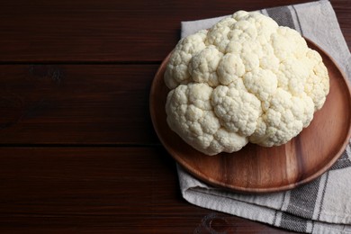 Plate with fresh raw cauliflower on wooden table, above view. Space for text