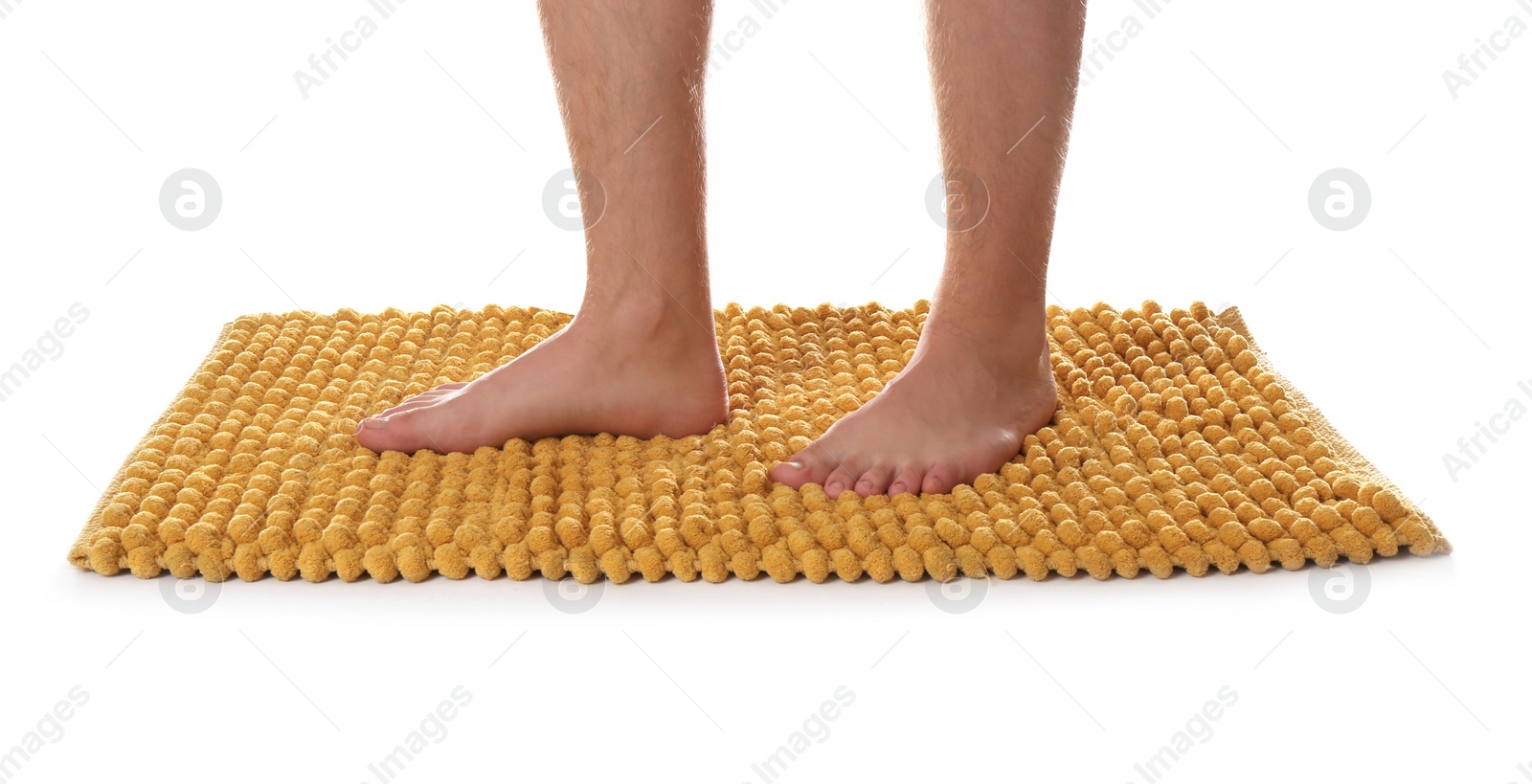 Photo of Man standing on soft orange bath mat against white background, closeup