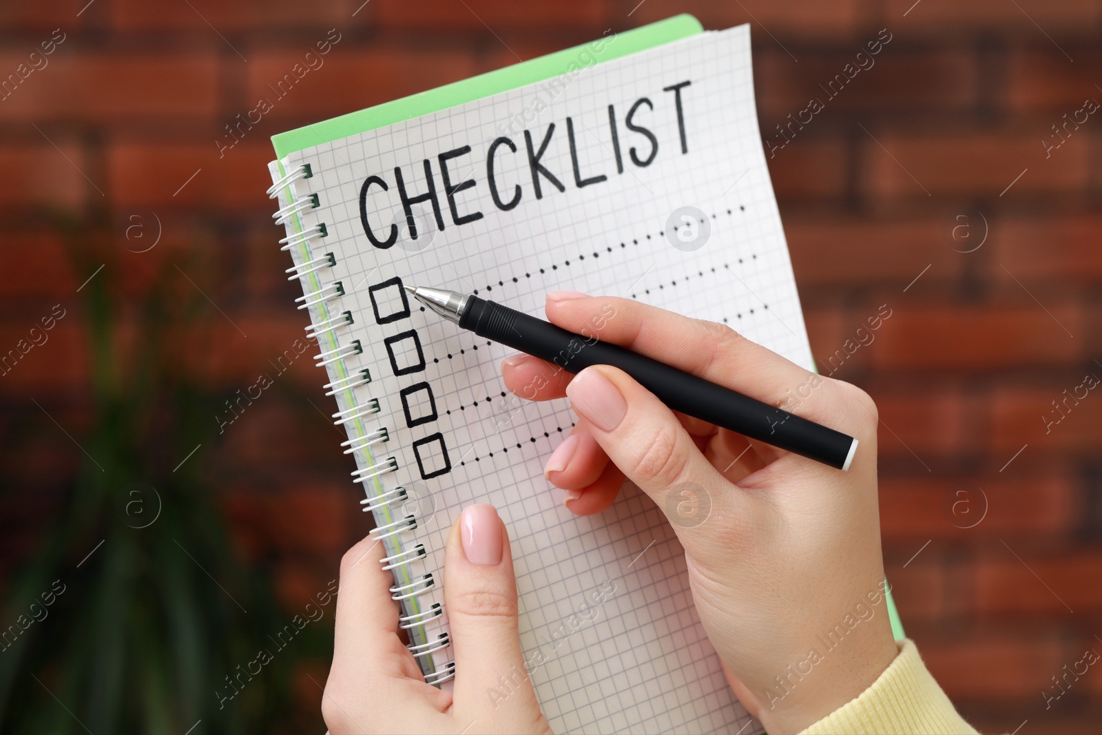 Photo of Woman filling Checklist with pen indoors, closeup