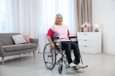 Mature woman sitting in wheelchair at home