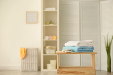 Clean towels and stones on table against blurred background