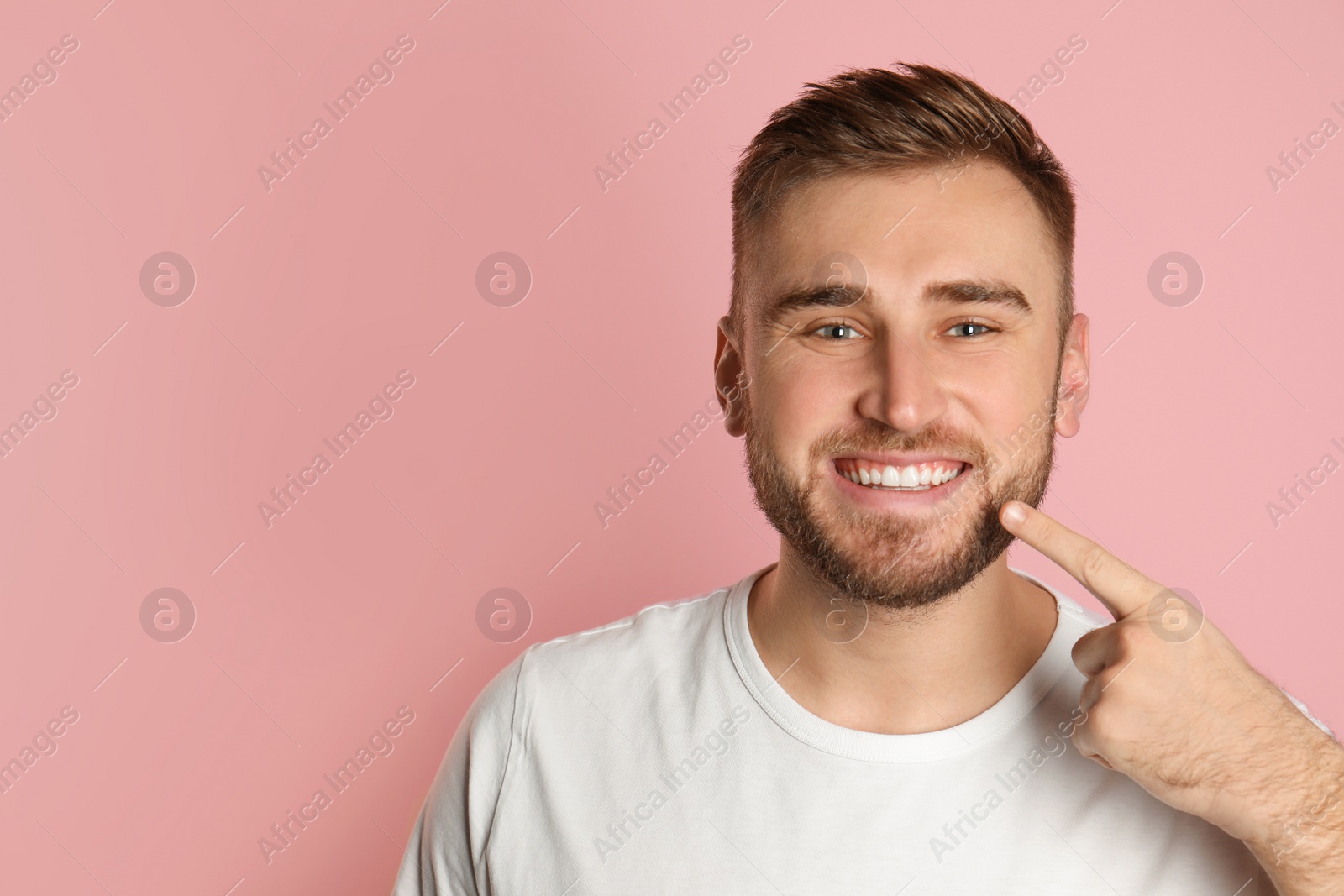 Photo of Young man with healthy teeth on color background. Space for text