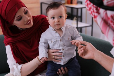 Happy Muslim family with little son in living room