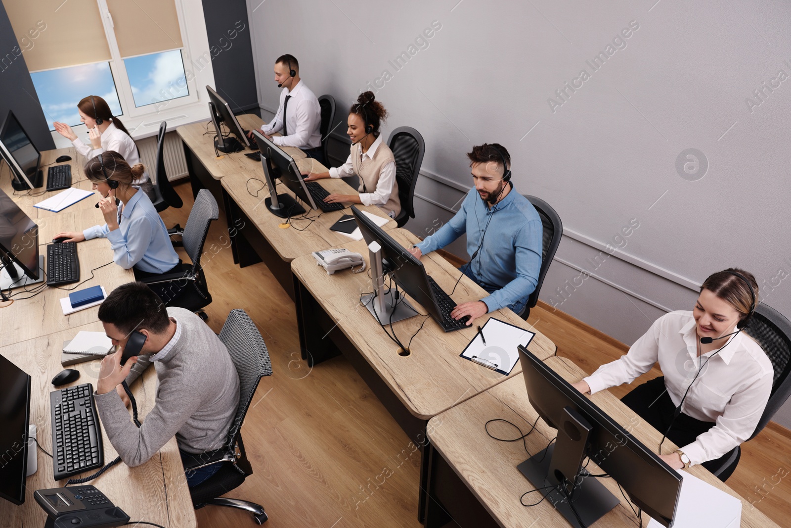 Photo of Call center operators working in modern office, above view