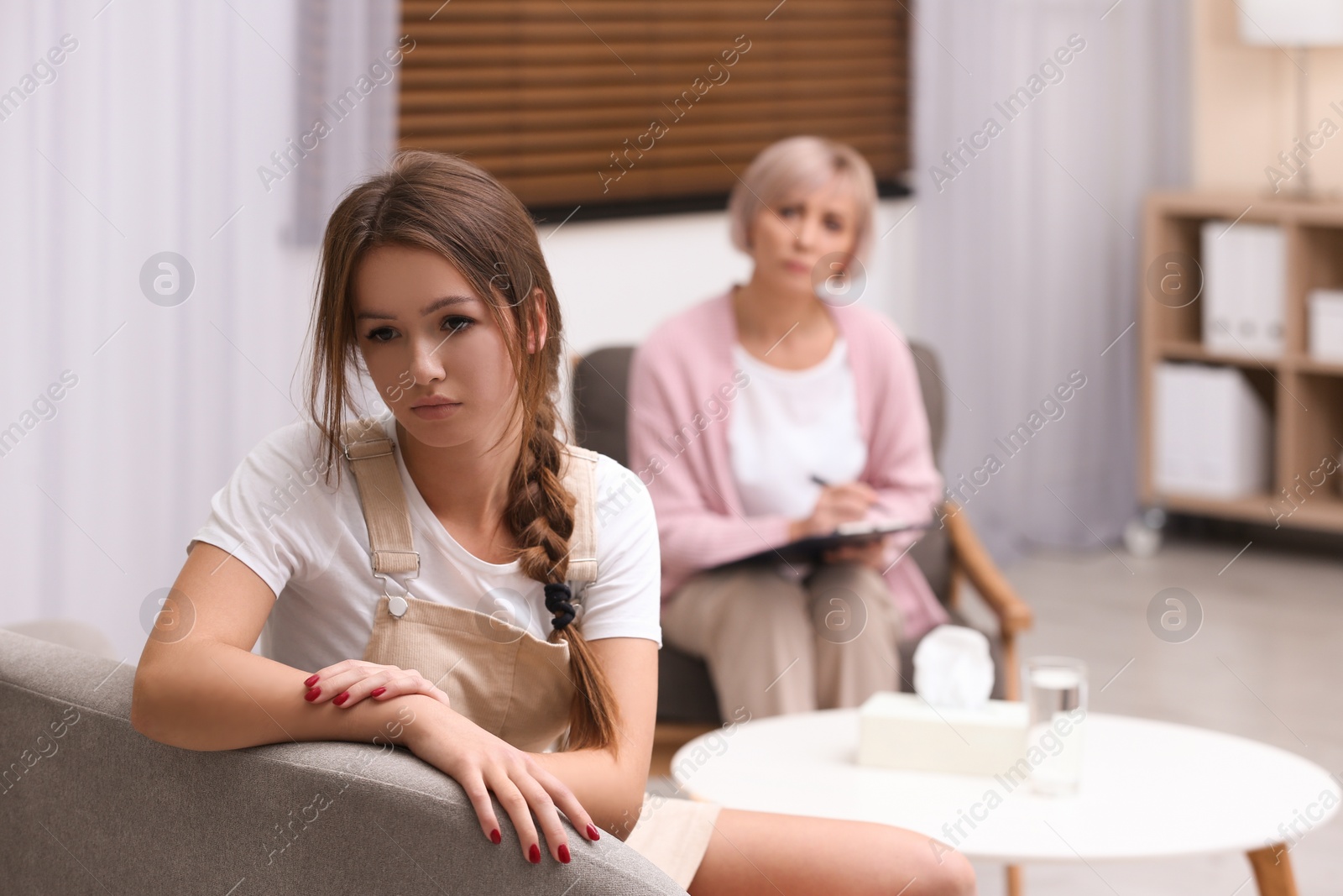 Photo of Psychotherapist working with teenage girl in office