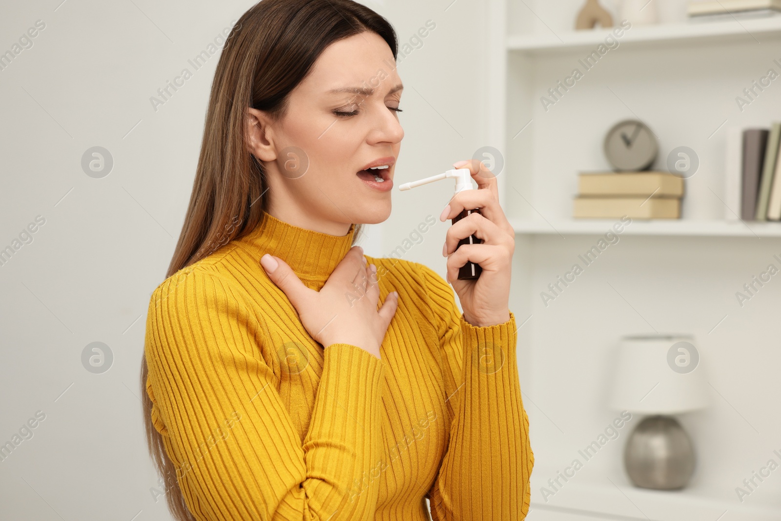 Photo of Adult woman using throat spray at home, space for text