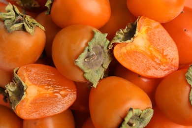 Photo of Tasty fresh ripe persimmons as background, closeup