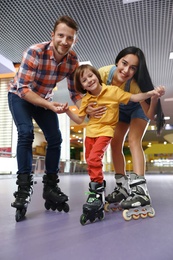 Photo of Happy family spending time at roller skating rink