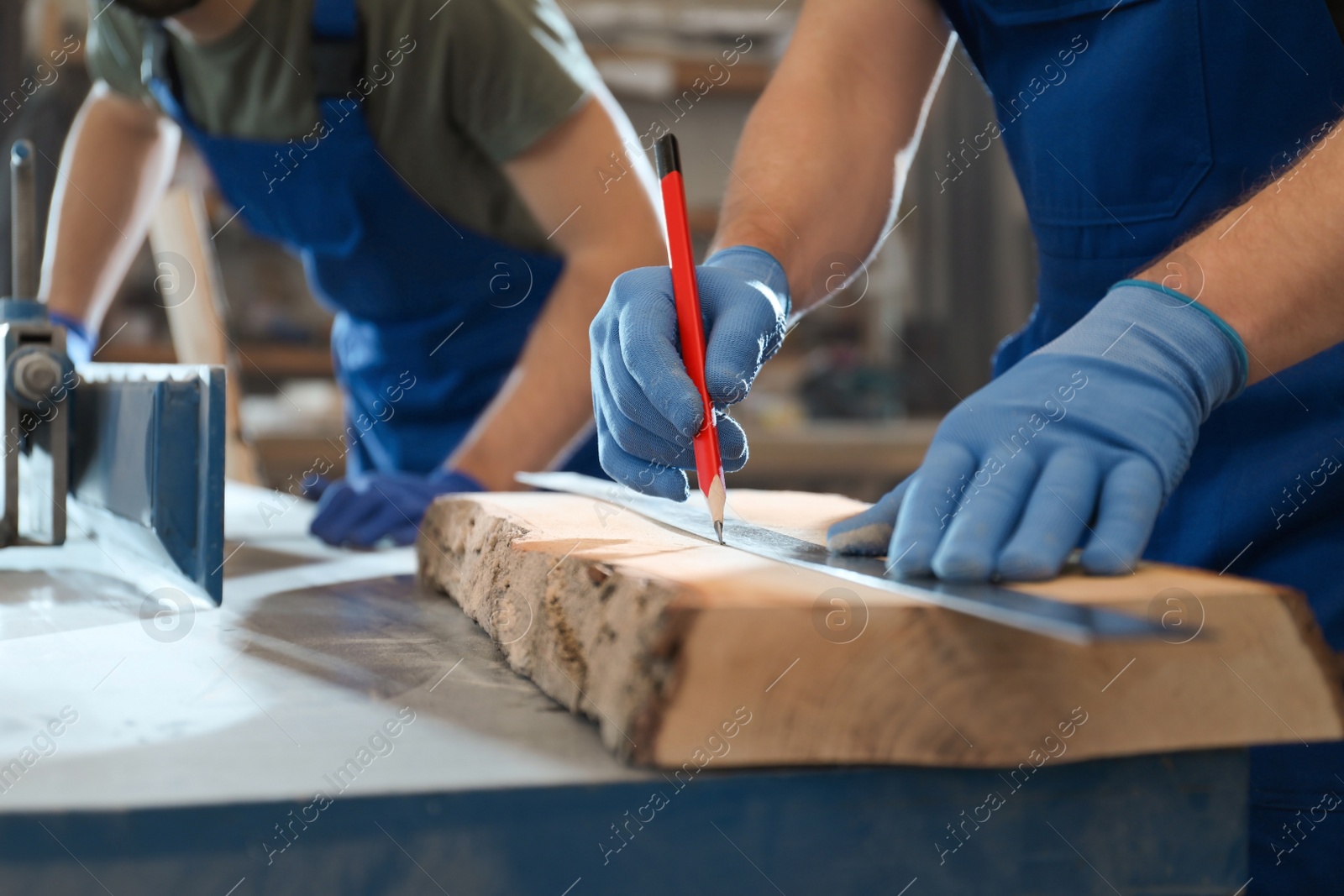 Photo of Professional carpenters working with wood in shop, closeup