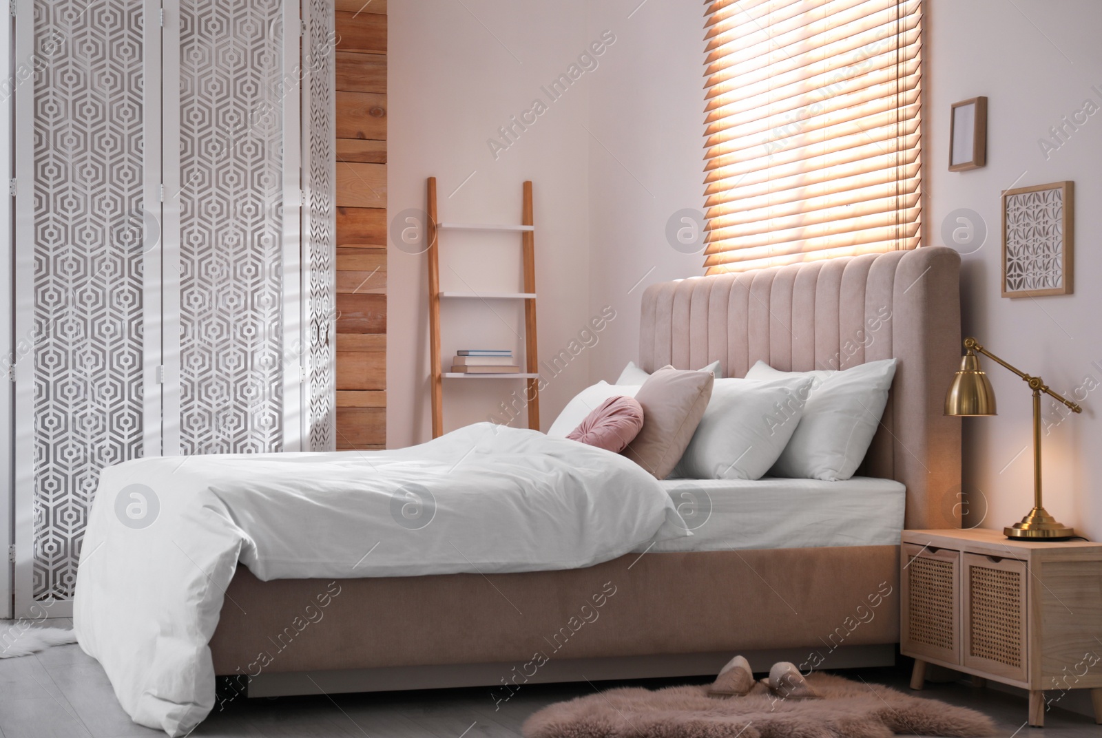 Photo of Cozy bed with soft linens in light room