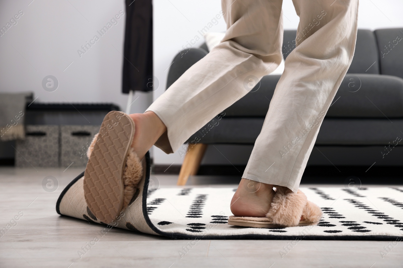 Photo of Woman tripping over carpet at home, closeup