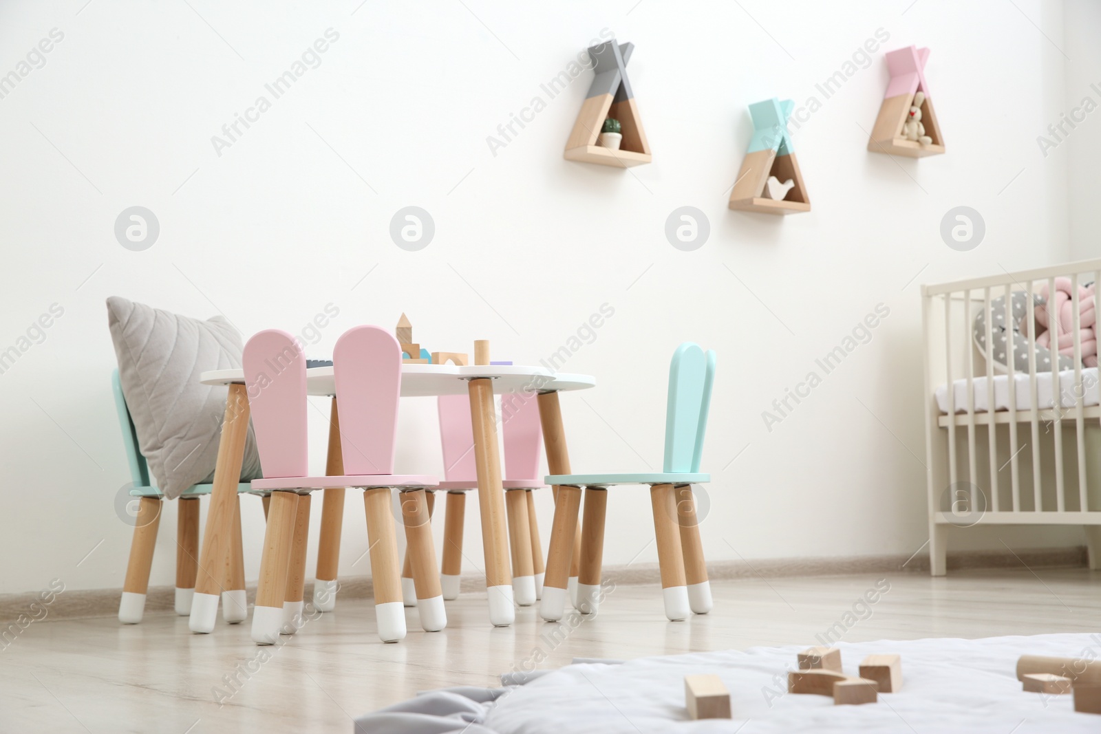 Photo of Cute baby room interior with cot and little table