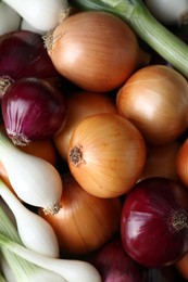 Different kinds of onions as background, top view