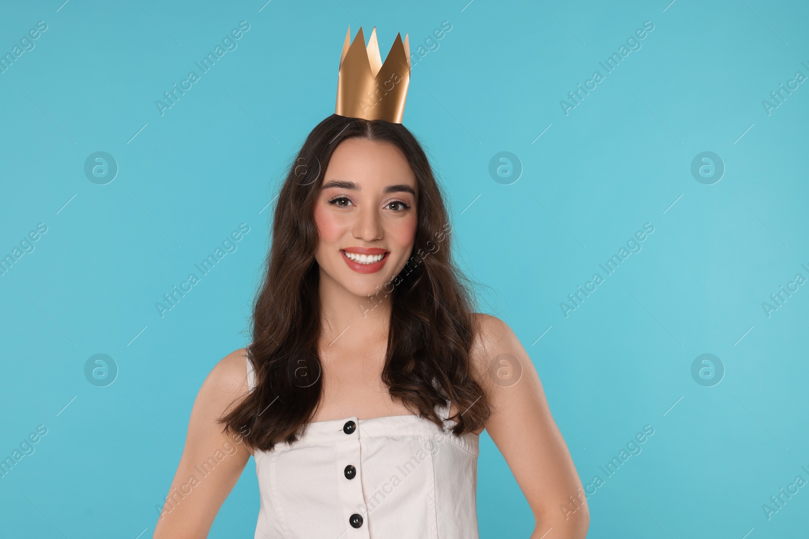 Photo of Beautiful young woman with princess crown on light blue background